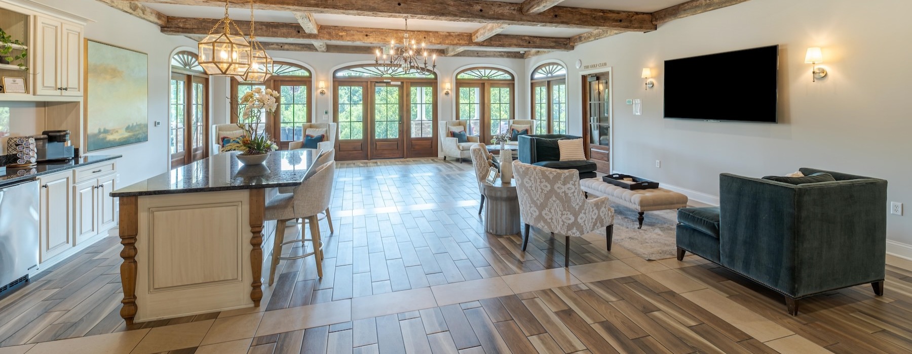 a clubroom with a tv, kitchen and chairs